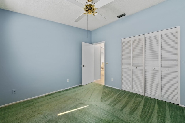 unfurnished bedroom with a textured ceiling, carpet floors, a closet, and ceiling fan