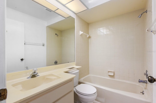 full bathroom featuring vanity, tiled shower / bath combo, and toilet