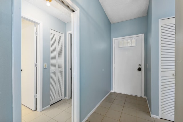 hallway with light tile patterned floors and a textured ceiling