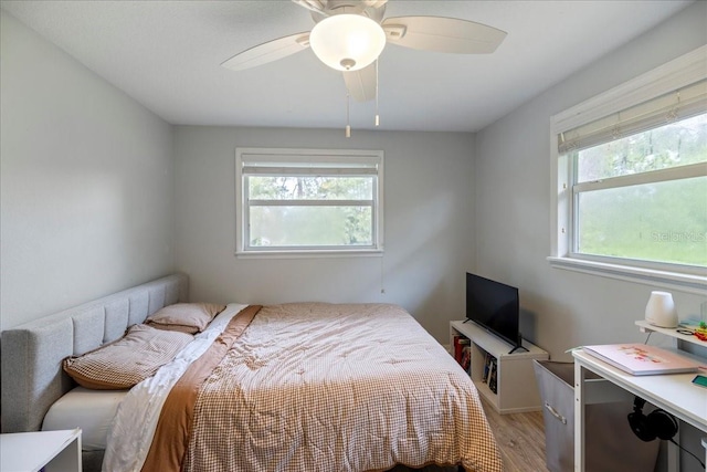 bedroom featuring multiple windows, light wood-type flooring, and ceiling fan