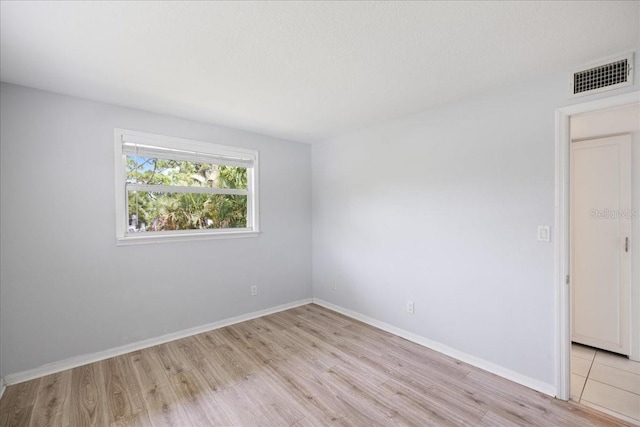 spare room with light hardwood / wood-style flooring