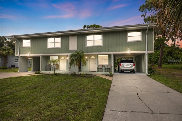 view of front of home featuring a lawn and a carport