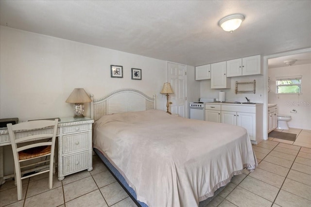 bedroom with ensuite bathroom, sink, and light tile patterned floors