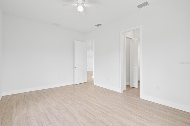 spare room with ceiling fan and light wood-type flooring