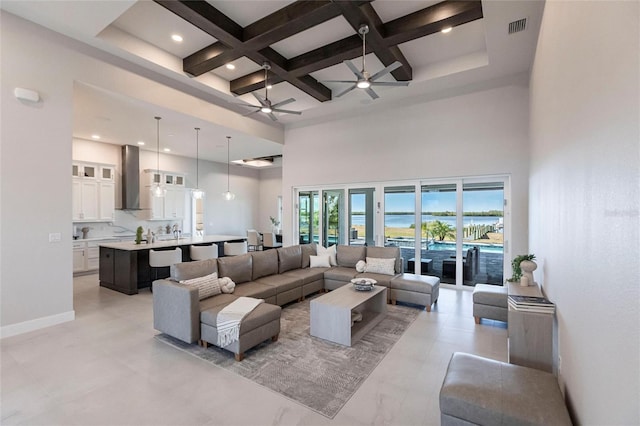 living room with visible vents, coffered ceiling, a ceiling fan, a towering ceiling, and beamed ceiling