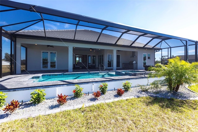 rear view of property with a ceiling fan, french doors, a patio area, and a lanai