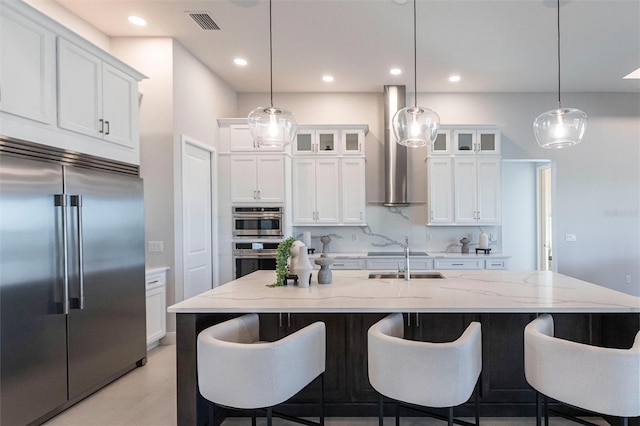 kitchen featuring stainless steel appliances, a breakfast bar, white cabinetry, and backsplash