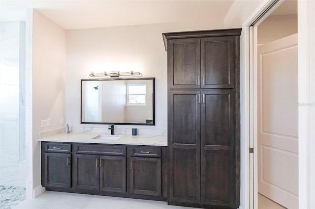 bathroom featuring tiled shower and vanity