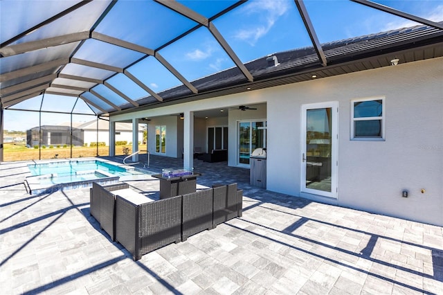 view of swimming pool with a pool with connected hot tub, outdoor lounge area, a ceiling fan, glass enclosure, and a patio area