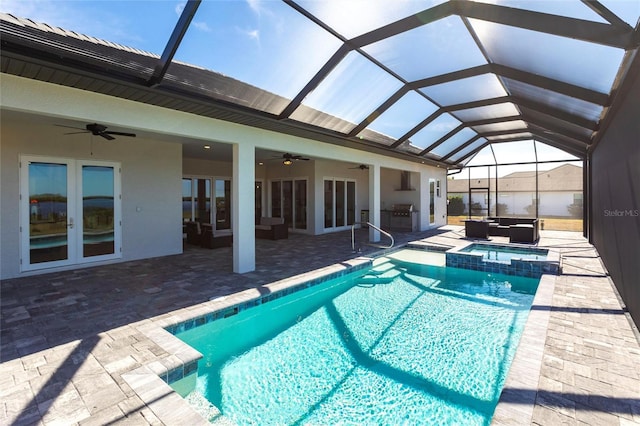 view of swimming pool with a patio, glass enclosure, a pool with connected hot tub, a ceiling fan, and french doors