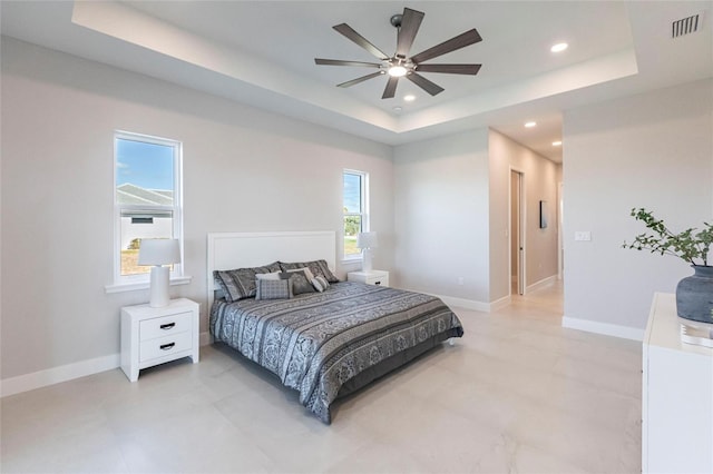 bedroom with a raised ceiling, visible vents, and baseboards