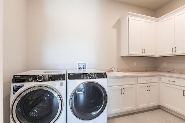 laundry area featuring cabinet space, washing machine and dryer, a sink, and light tile patterned flooring