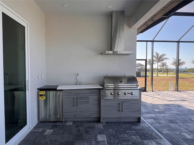 view of patio / terrace featuring glass enclosure, a sink, and area for grilling