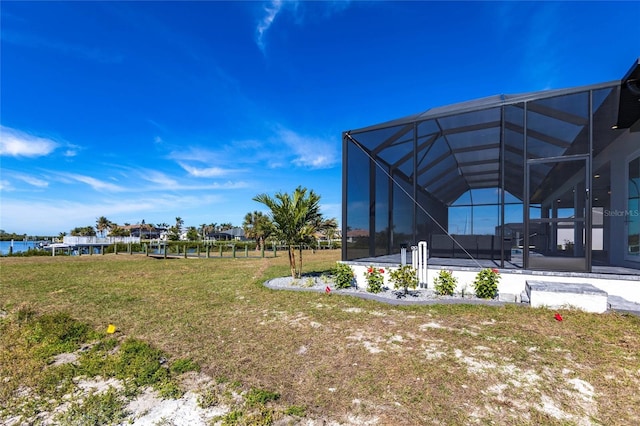 view of yard featuring a water view and glass enclosure