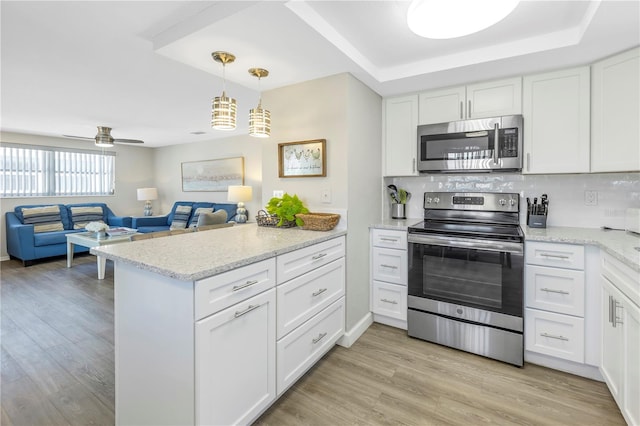 kitchen with appliances with stainless steel finishes, white cabinetry, and pendant lighting