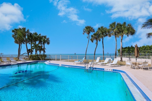 view of swimming pool featuring a patio area and a water view