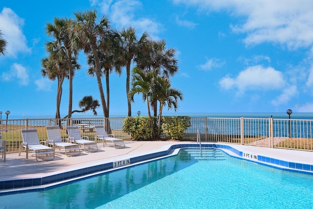 view of pool featuring a patio area and a water view