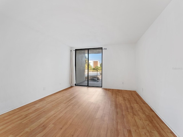 spare room with light wood-type flooring and floor to ceiling windows