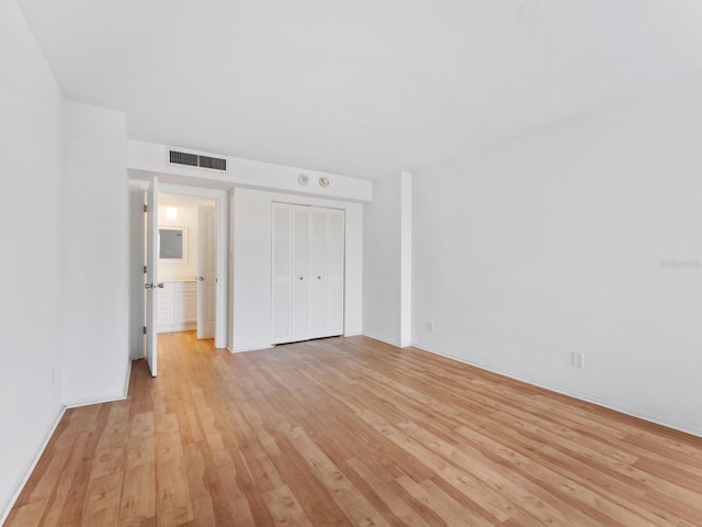 unfurnished bedroom with a closet and light wood-type flooring