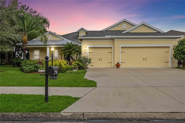 view of front of house with a garage and a lawn