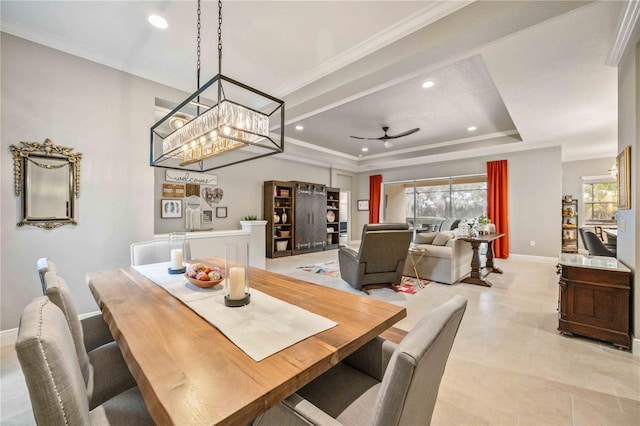 tiled dining room featuring ceiling fan with notable chandelier, crown molding, and a tray ceiling