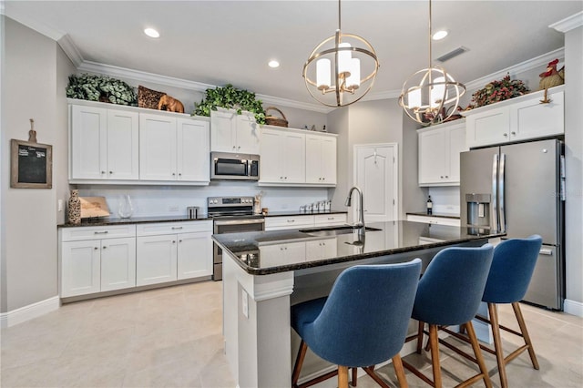 kitchen featuring stainless steel appliances, sink, a center island with sink, and white cabinets