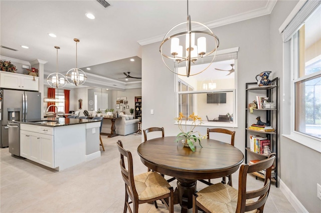 dining area with crown molding, ceiling fan with notable chandelier, sink, and light tile patterned floors