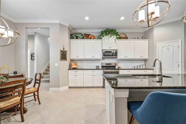 kitchen featuring white cabinetry, appliances with stainless steel finishes, sink, and pendant lighting