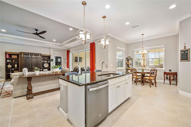 kitchen featuring pendant lighting, white cabinetry, sink, stainless steel dishwasher, and a center island with sink