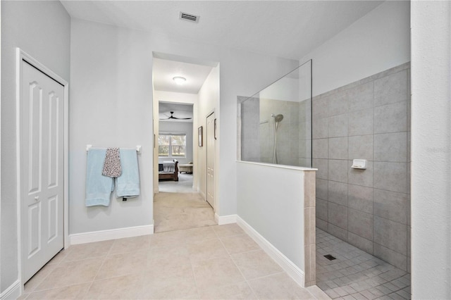 bathroom featuring ceiling fan, tile patterned floors, and a tile shower