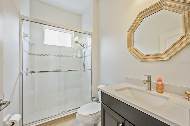 bathroom featuring vanity, a shower with door, and toilet