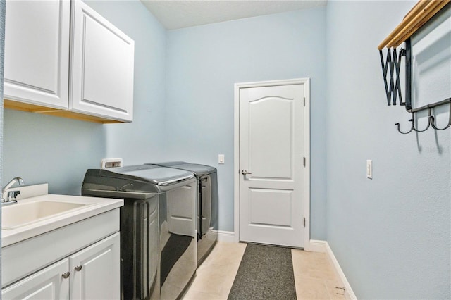 laundry room featuring cabinets, washer and clothes dryer, sink, and light tile patterned floors