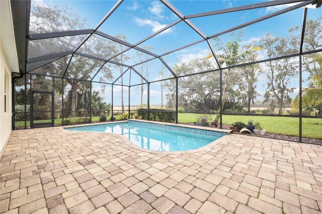 view of pool with a lanai, a patio, and a lawn