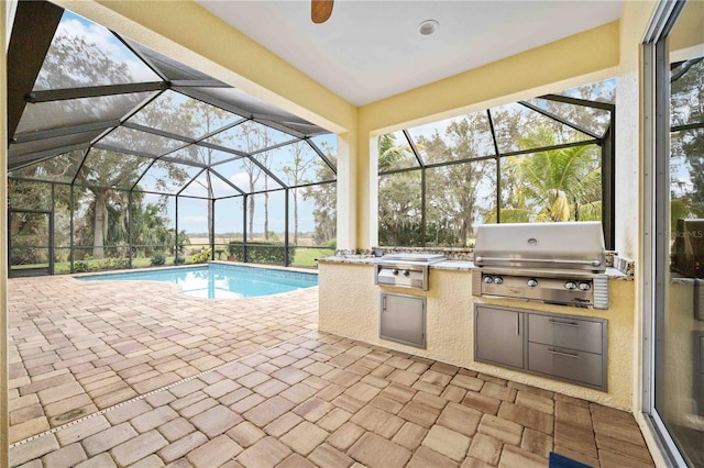 view of pool with a grill, a lanai, a patio, and an outdoor kitchen