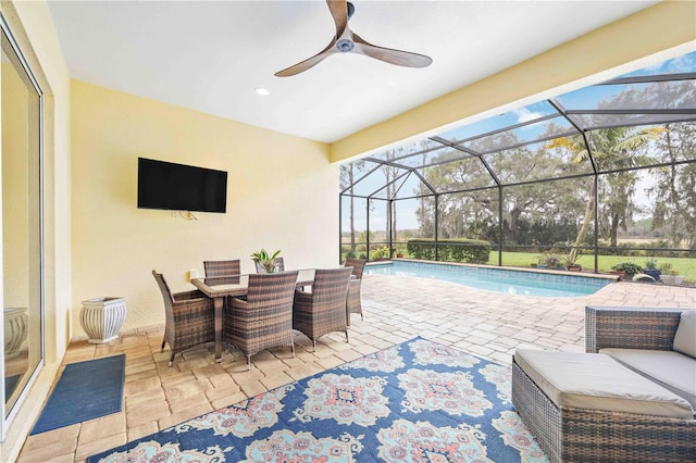 view of swimming pool featuring ceiling fan, a lanai, and a patio area