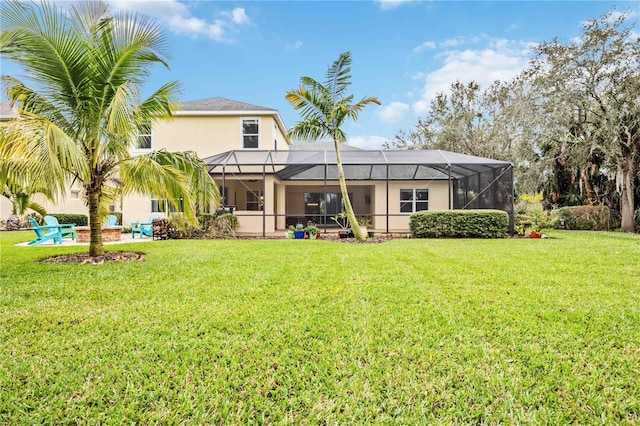 back of property featuring glass enclosure and a lawn