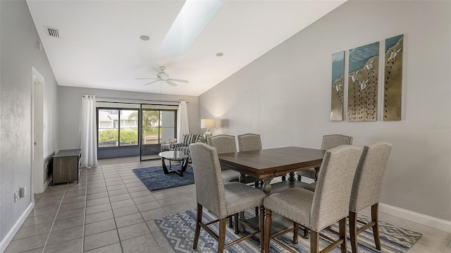 tiled dining space with a skylight and ceiling fan