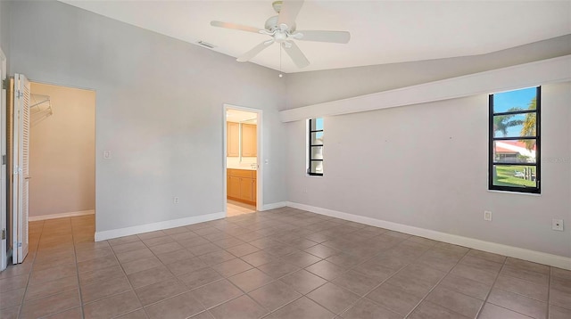 spare room featuring lofted ceiling, ceiling fan, and light tile flooring