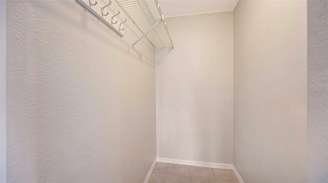 walk in closet featuring light tile floors