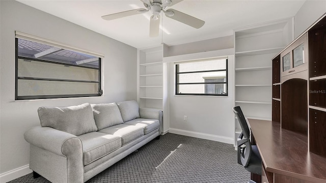 home office with dark colored carpet and ceiling fan