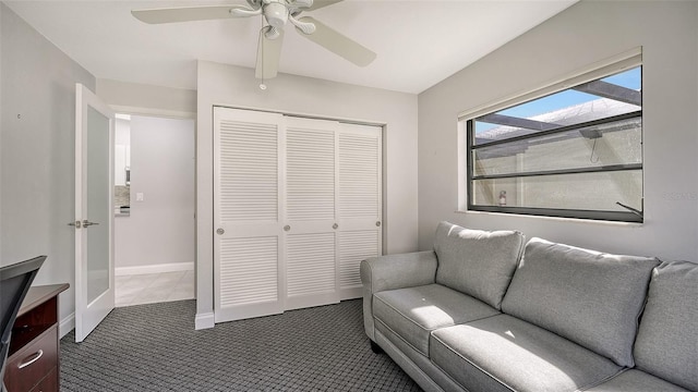 sitting room featuring dark colored carpet and ceiling fan