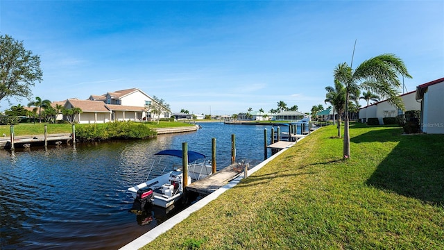 view of dock with a lawn and a water view