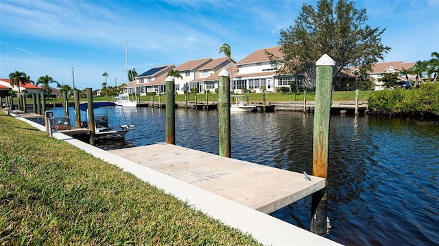 dock area with a lawn and a water view