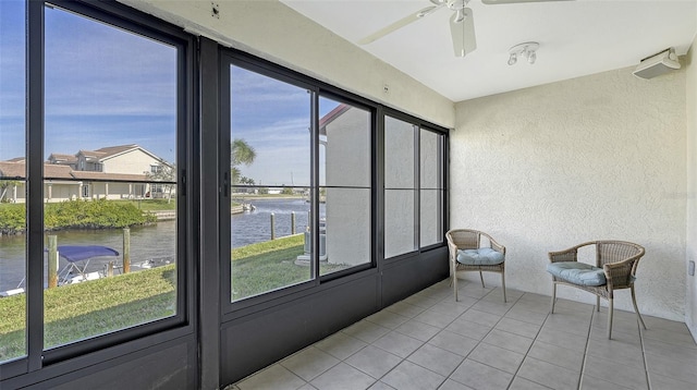 unfurnished sunroom with a water view and ceiling fan