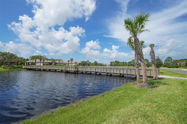 dock area with a lawn and a water view