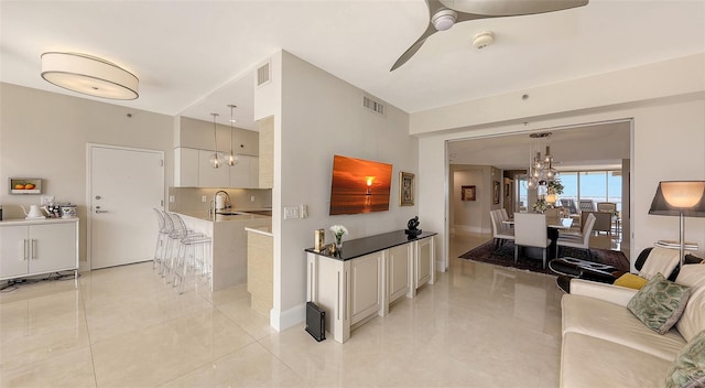 tiled living room featuring ceiling fan and sink