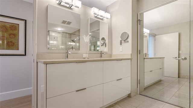 bathroom with tile patterned floors, vanity, and walk in shower