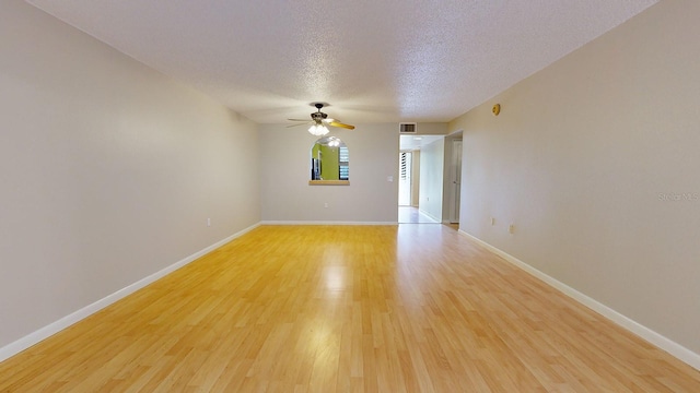 spare room featuring a textured ceiling, ceiling fan, and light hardwood / wood-style floors