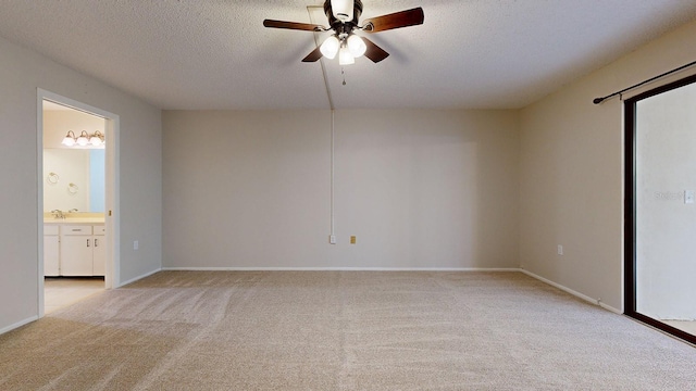 unfurnished room featuring a textured ceiling, light colored carpet, sink, and ceiling fan