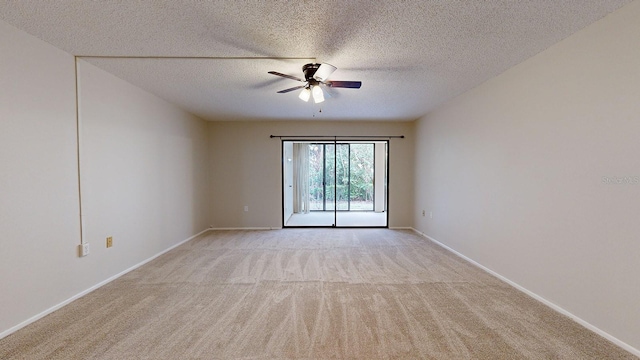 carpeted spare room featuring a textured ceiling and ceiling fan